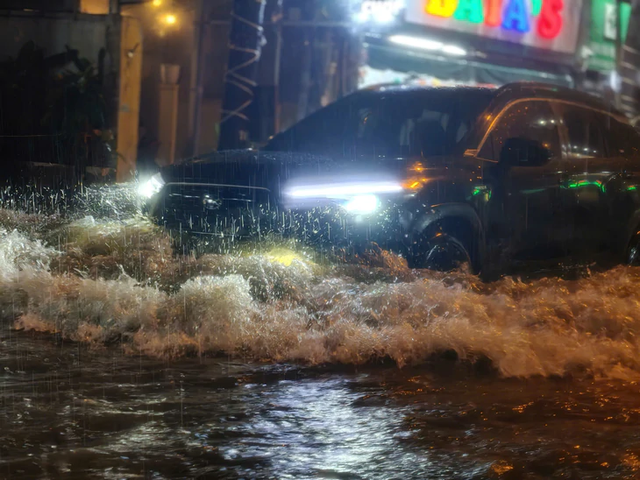 Heavy rain turns streets into torrents, knocks motorcyclists down in Ho Chi Minh City - Ảnh 11.