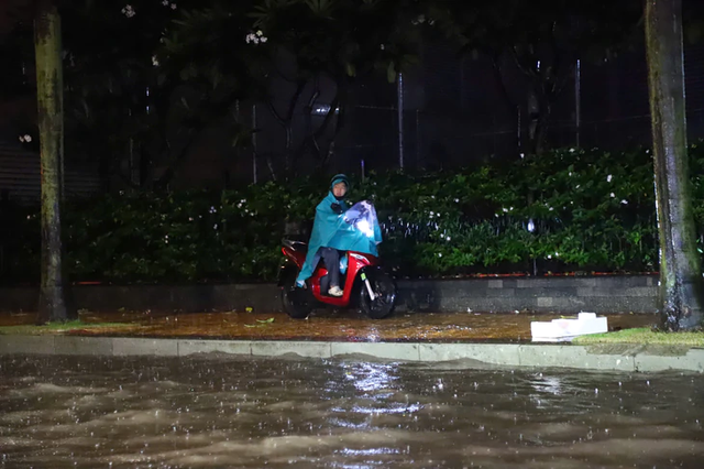 Heavy rain turns streets into torrents, knocks motorcyclists down in Ho Chi Minh City - Ảnh 13.