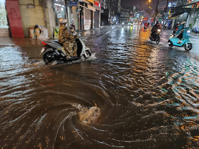 Heavy rain turns streets into torrents, knocks motorcyclists down in Ho Chi Minh City - Ảnh 17.