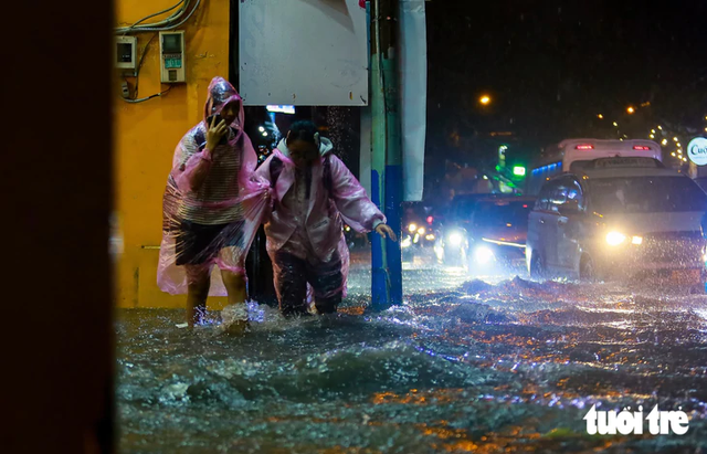 Heavy rain turns streets into torrents, knocks motorcyclists down in Ho Chi Minh City - Ảnh 6.