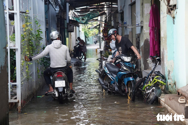 Ho Chi Minh City commuters, students struggle as morning tides rise - Ảnh 4.