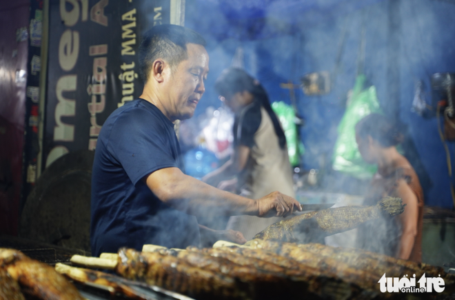 Charcoal burns overnight as vendors prepare grilled snakehead fish for God of Wealth Day in Ho Chi Minh City- Ảnh 7.