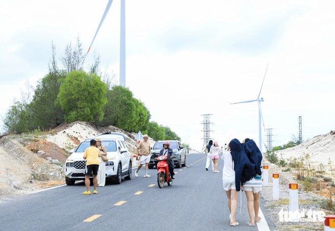 Visitors flout road safety for photos at central Vietnam's wind farm - Ảnh 2.