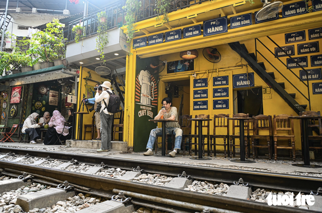 Hanoi’s trackside coffee street remains bustling after foreign tourist’s phone knocked away by train- Ảnh 1.