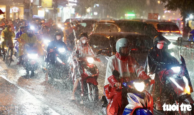 Heavy rain floods streets, disrupts evening commute in Ho Chi Minh City- Ảnh 9.