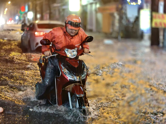 Heavy rain turns streets into torrents, knocks motorcyclists down in Ho Chi Minh City - Ảnh 7.