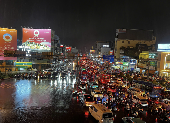 Downpours during rush hour causes severe flooding, traffic jams in Ho Chi Minh City - Ảnh 2.