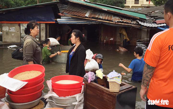 Tiểu thương Vinh lao đao cứu hàng trong nước ngập thắt lưng - Ảnh 1. Tiểu thương Vinh lao đao cứu hàng trong nước ngập thắt lưng - Ảnh 1.
