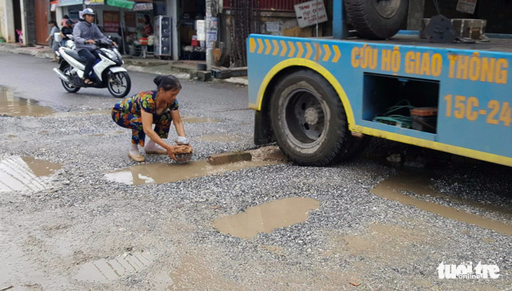 Đường 14 tỉ phập phều như bánh tráng, dân mang đá ra vá - Ảnh 2.