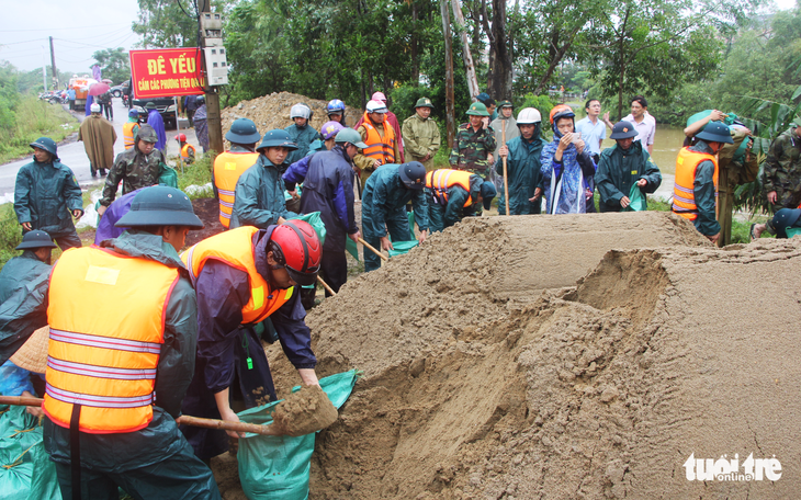Hơn 500 người hộ đê sông Vinh trong mưa lớn - Ảnh 1. Hơn 500 người hộ đê sông Vinh trong mưa lớn - Ảnh 1.
