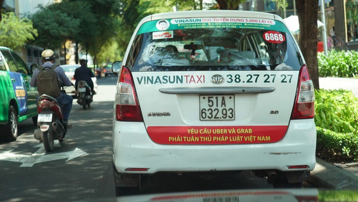 Taxi Vinasun ở Sài Gòn bị yêu cầu tháo bảng phản đối Uber - Grab - Ảnh 1.