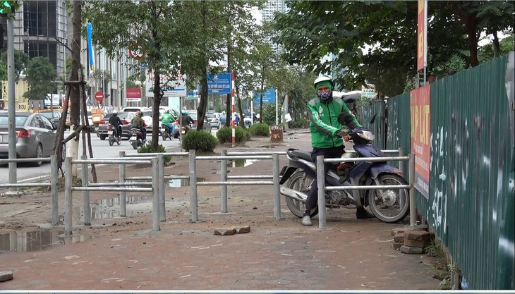 Hà Nội dựng rào chắn trên vỉa hè, dân đi ngược chiều dưới lòng đường - Ảnh 5.