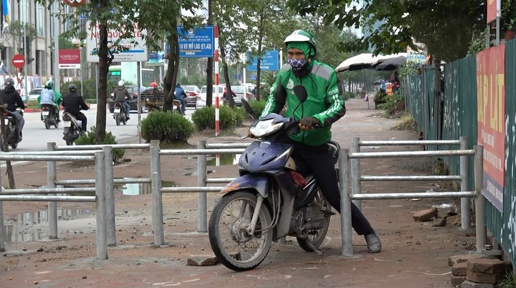 Hà Nội dựng rào chắn trên vỉa hè, dân đi ngược chiều dưới lòng đường - Ảnh 2.