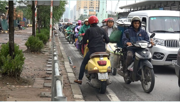 Hà Nội dựng rào chắn trên vỉa hè, dân đi ngược chiều dưới lòng đường - Ảnh 7.