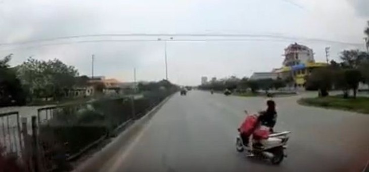 Cởi áo mưa khi đi xe máy, hai mẹ con thoát chết trong gang tấc - Ảnh 2.