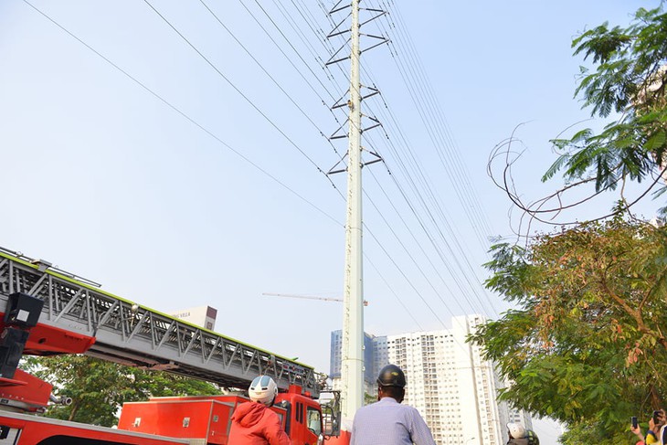 Cảnh sát đưa xe thang và đệm hơi ứng cứu thanh niên cố thủ trên cột điện cao thế - Ảnh 2.