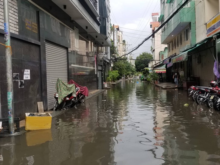 Chiều chủ nhật mưa rơi, người dân TP.HCM lại bì bõm lội nước - Ảnh 4. Chiều chủ nhật mưa rơi, người dân TP.HCM lại bì bõm lội nước - Ảnh 4.