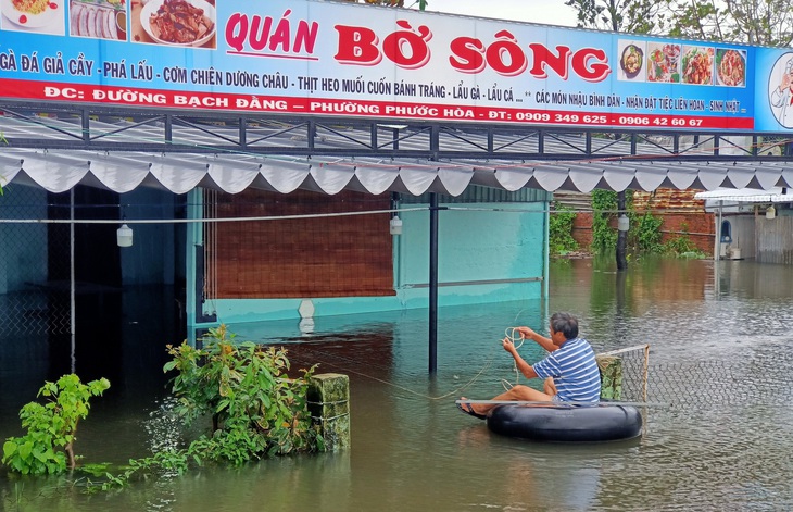 Mưa lớn, hồ xả lũ, một số khu vực tại Tam Kỳ ngập nặng, dân dùng thuyền đi lại - Ảnh 1.