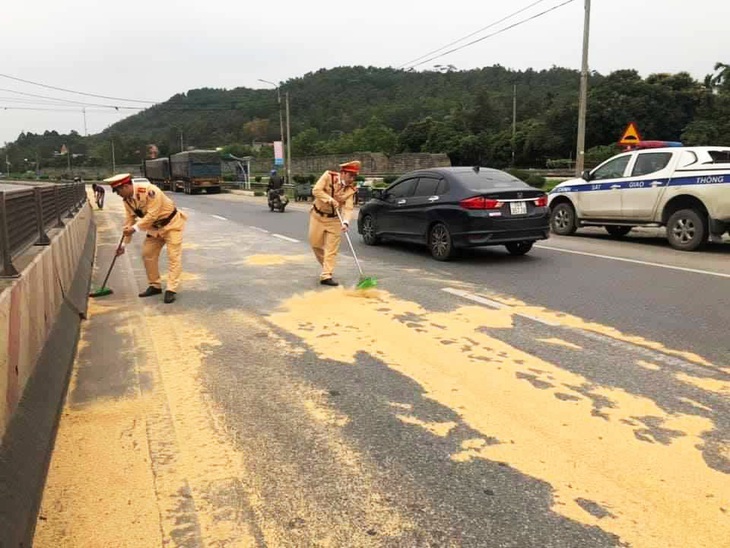 Cảnh sát giao thông và người dân giúp tài xế gom 4 tấn đỗ tương rớt xuống đường - Ảnh 4.