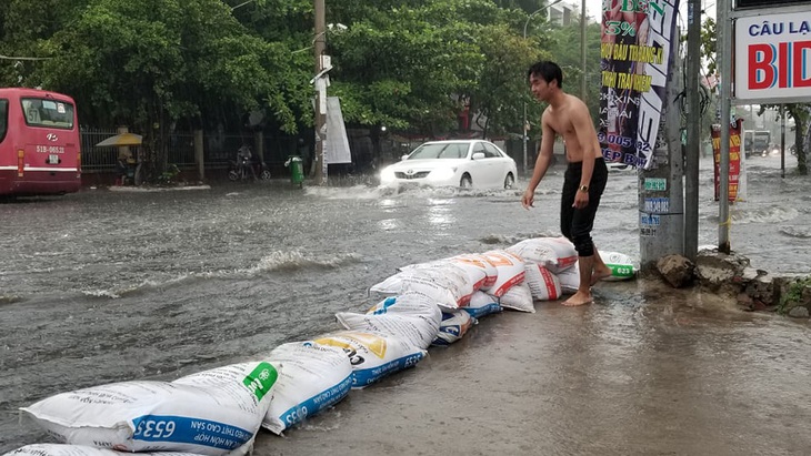 Mưa như trút nước, người dân lấy bao cát chắn nước tràn vào nhà - Ảnh 1.