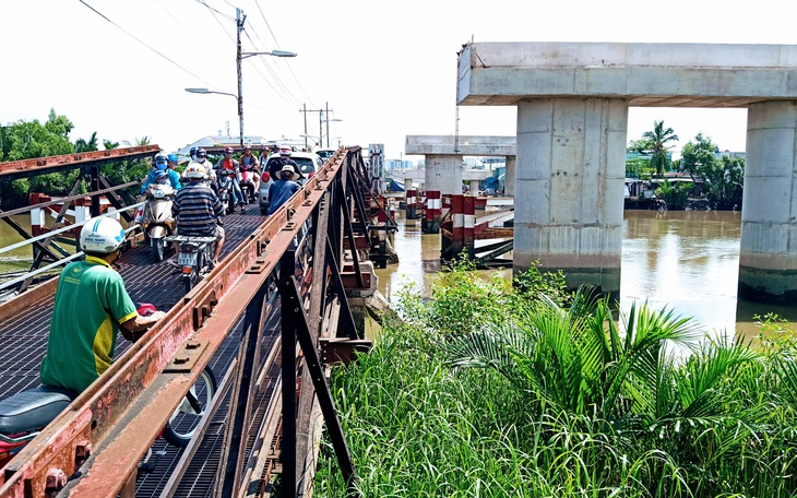 Xây cầu Long Kiểng dở dang, dân chen nhau qua cầu sắt ọp ẹp