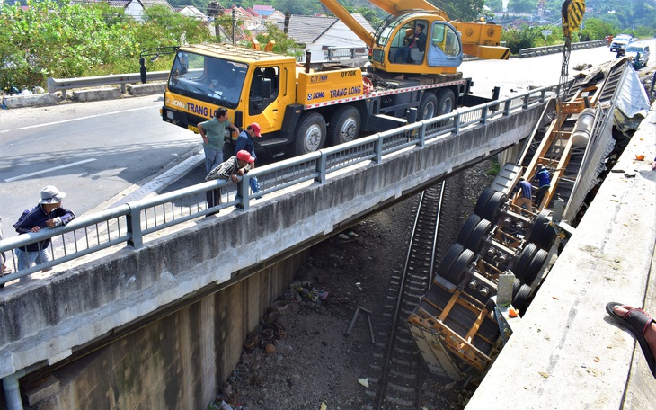 Xe đầu kéo húc lan can cầu vượt, rơi ngửa trên đường sắt, cả tấn quýt tết văng vãi