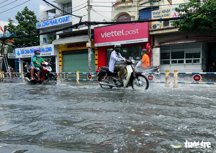 Mưa chưa tới nửa tiếng, nhiều đường phố TP.HCM đã mênh mông nước - Ảnh 3.