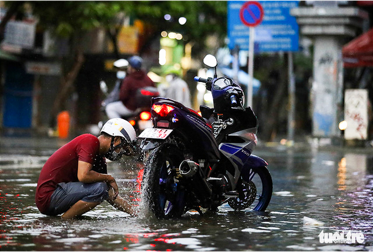 Mưa đúng lúc triều cường, đường ở trung tâm TP.HCM ngập cả bánh xe - Ảnh 7.