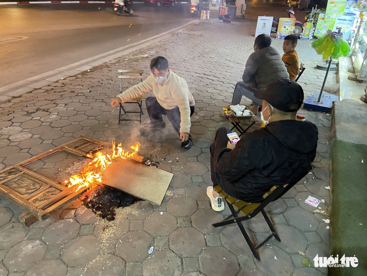 Người lao động co ro trong cái rét tê tái 10 độ C giữa đêm đông Hà Nội - Ảnh 1.