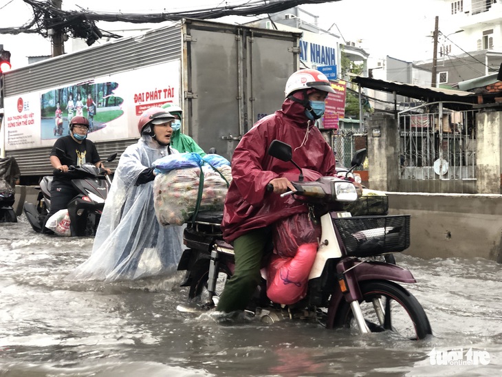 Mưa trắng trời, người dân TP.HCM lại lội nước giữa trưa - Ảnh 4.