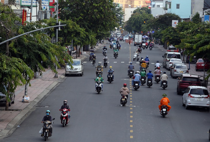 Gần trưa, đường phố TP.HCM vẫn đông người đi lại - Ảnh 2.