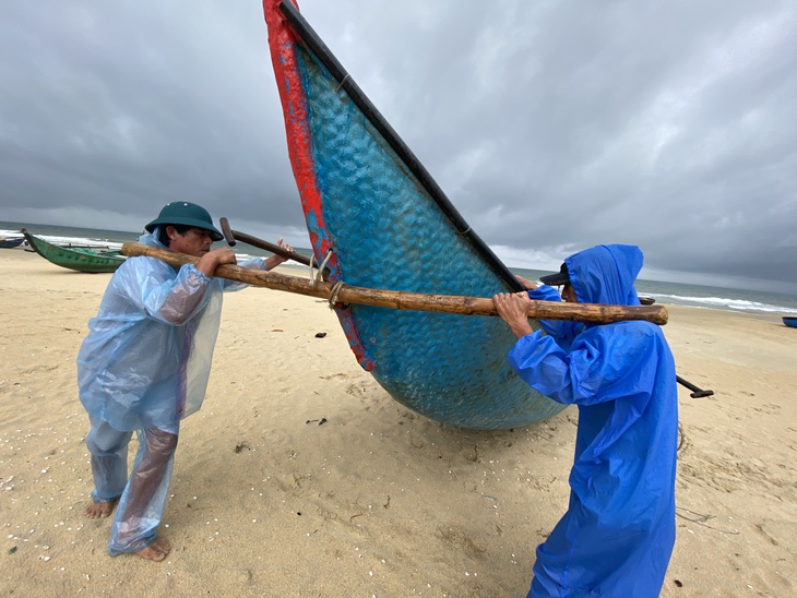 Ngư dân Quảng Nam hối hả đưa ghe thuyền lên bờ - Ảnh 4. Ngư dân Quảng Nam hối hả đưa ghe thuyền lên bờ - Ảnh 4.