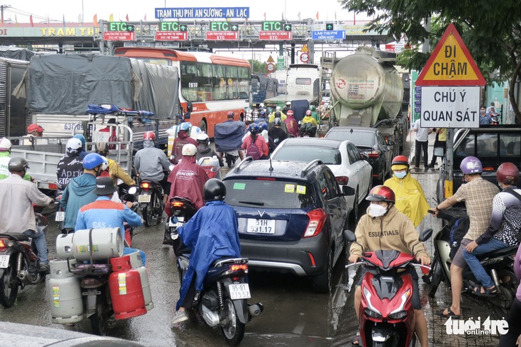 Quốc lộ 1 ùn 7km, trạm thu phí An Sương phải mở thêm làn thu tiền mặt - Ảnh 1.