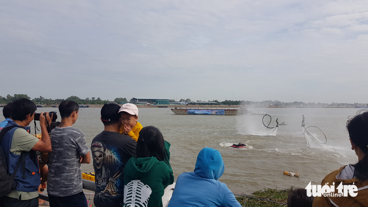 Người dân chen kín bờ kè sông Tiền xem flyboard, dù lượn - Ảnh 4.