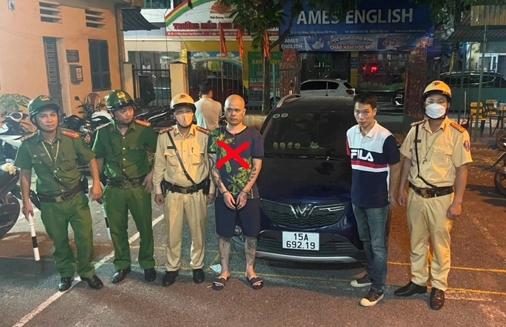 Khởi tố hai người tham gia giao thông chống đối khi bị kiểm tra tại Hải Phòng - Ảnh 1. Tổ công tác Công an quận Hồng Bàng, Hải Phòng đưa trường hợp Nguyễn Hoàng Nam (đầu trọc) về trụ sở Công an phường Hoàng Văn Thụ giải quyết vì có hành vi chống đối - Ảnh: Công an Hồng Bàng