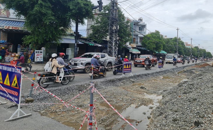 Làm đường vào mùa mưa, phụ thuộc vào ông trời nên chưa biết ngày hoàn thành. Người dân phải vật vạ lưu thông trên đường tạm nhỏ hẹp - Ảnh: TRẦN MAI