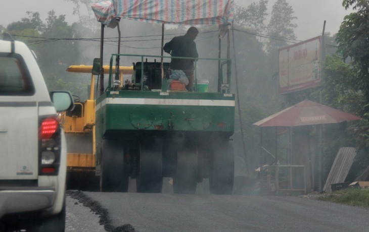 Đơn vị thi công đang thảm nhựa giữa lúc trời đang mưa - Ảnh: KH.TRÀ