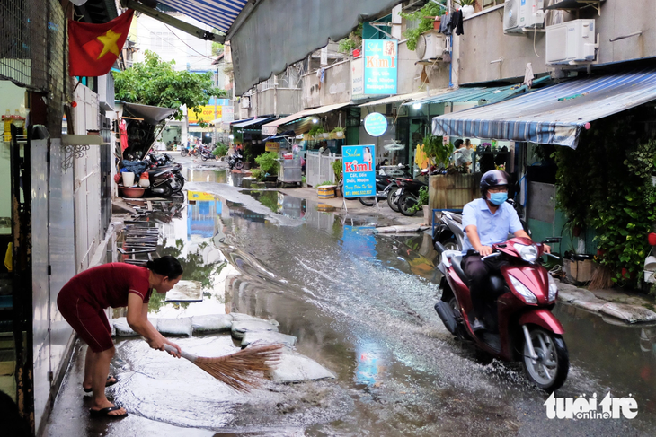 Do bể cống thoát nước, người dân tại tầng trệt chung cư Ấn Quang phải liên tục quét nước cống trước cửa nhà - Ảnh: PHƯƠNG NHI