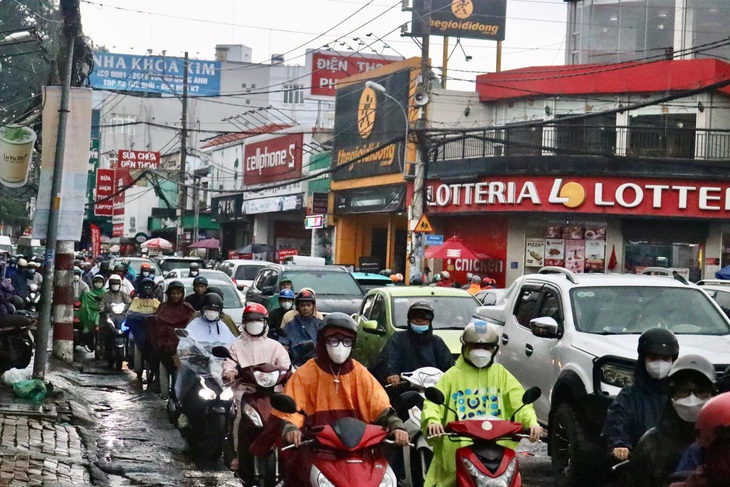 Mưa và xe đông sáng đầu tuần khiến một số người trễ giờ học, giờ làm - Ảnh: NGỌC QUÝ 