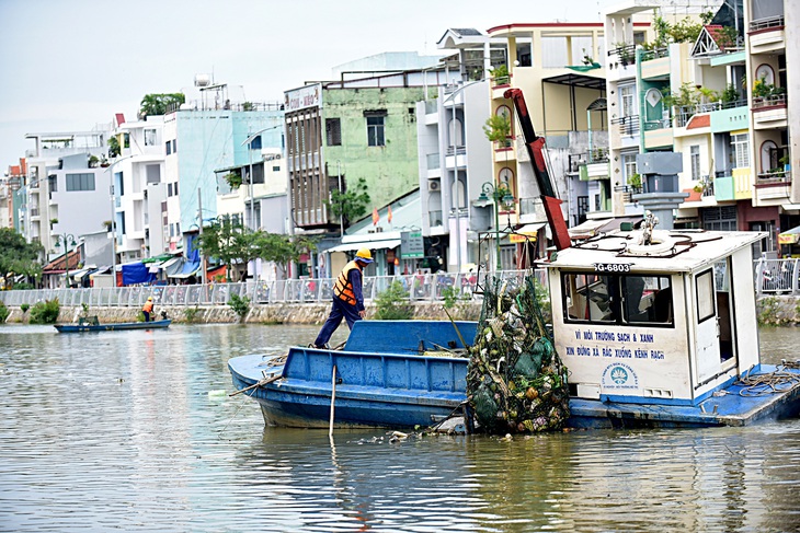 Công nhân môi trường vớt rác trên kênh Lò Gốm, quận 8, TP.HCM - Ảnh: T.T.D.