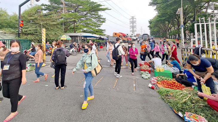 Nhiều công nhân sau giờ tan ca đã tranh thủ bán hàng ngay gần nhà máy mình làm để kiếm thêm thu nhập - Ảnh: MẠNH DŨNG