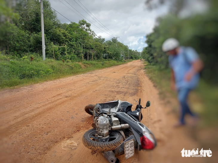 Đường đất đỏ có cát nên vừa lách xe qua một bên, khách du lịch đã bị ngã té ra đường - Ảnh: CHÍ CÔNG