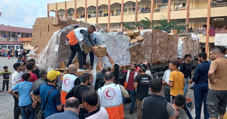 Nhân viên Hội Trăng lưỡi liềm đỏ trao hàng viện trợ cho người dân ở Deir al-Balah, Gaza ngày 25-10 - Ảnh: REUTERS