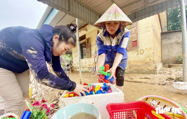 Các cô giáo mầm non huyện Quỳ Châu tìm lại dụng cụ học tập của học sinh sau mưa lũ - Ảnh: DOÃN HÒA