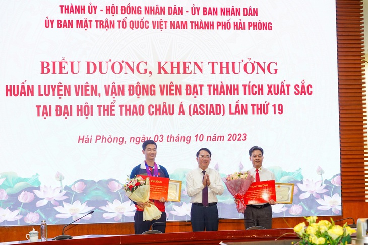 Lãnh đạo TP Hải Phòng trao bằng khen và số tiền thưởng hơn 300 triệu đồng cho hai thầy trò xạ thủ Phạm Quang Huy - Ảnh: Đ.THANH