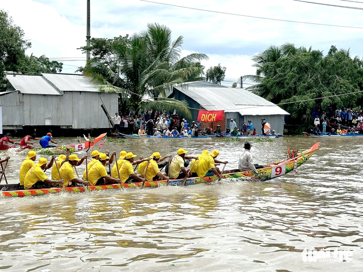 Hai đội đua ghe ngo (số 5) huyện Giồng Riềng và đội đua ghe ngo (số 9) huyện Gò Quao tranh tài về đích - Ảnh: HOA ÁNH