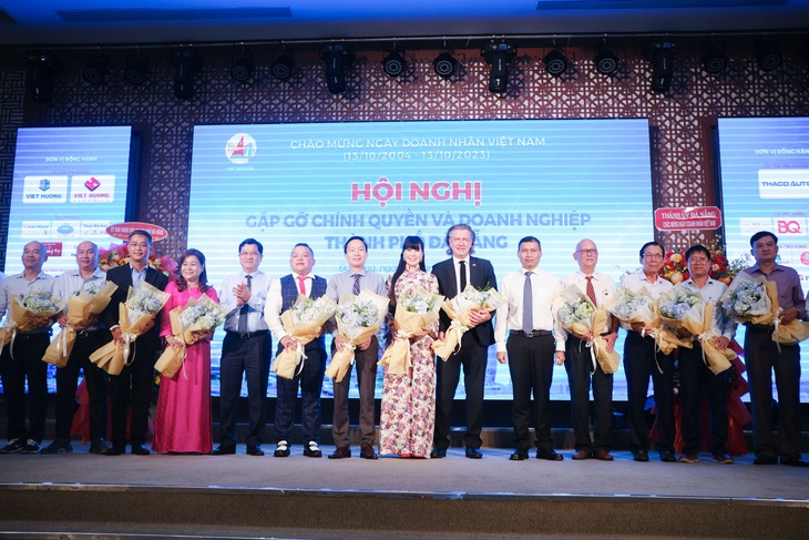 Doanh nghiệp kiến nghị gỡ khó, thúc đẩy kinh doanh - Ảnh 3. Chính quyền TP Đà Nẵng trao hoa cho đại diện các hiệp hội doanh nghiệp - Ảnh: TẤN LỰC