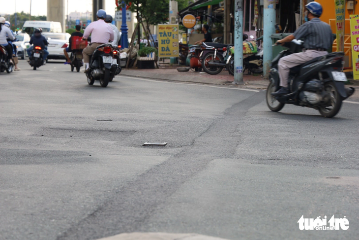 Nhựa mới giặm vá đan xen nhựa cũ tại khúc giao đường Võ Văn Ngân - Đặng Văn Bi như &quot;tấm áo vá&quot;. Trả lời Tuổi Trẻ Online về giải pháp khắc phục tình trạng đường Võ Văn Ngân, ông Nguyễn Tuấn Khanh - giám đốc Ban quản lý dự án đầu tư xây dựng khu vực TP Thủ Đức - cho biết dự án xây dựng hệ thống thoát nước đường này đang tạm ngưng, các hạng mục ngầm chưa thi công hoàn chỉnh. Điều này dẫn tới chưa đảm bảo việc tái lập được, người dân gặp khó khăn khi qua đây - Ảnh: NGỌC QUÝ