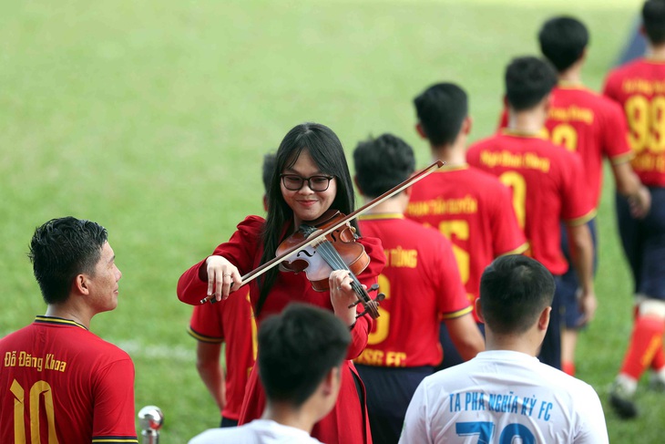 Cầu thủ phong trào thích thú khi bước ra sân trong sự chào đón của nhạc sĩ violin - Ảnh: N.K.