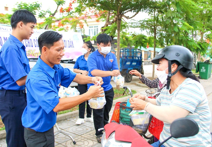 Anh Thanh cùng nhiều đoàn viên thanh niên phát cơm miễn phí cho người nghèo, công việc này mỗi tháng một lần và đã duy trì nhiều năm - Ảnh: TRẦN MAI